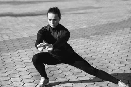 Young athletic woman doing stretching on the city embankmentの写真素材