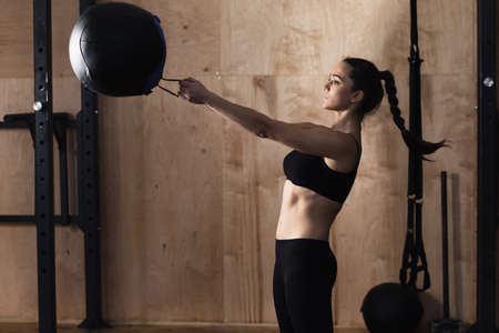 Woman lift weight ball at the gymの写真素材