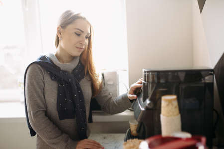 Attractive woman makes a coffee on the coffee machineの写真素材