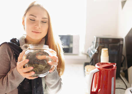 Attractive woman enjoying the aroma tea at kitchenの写真素材