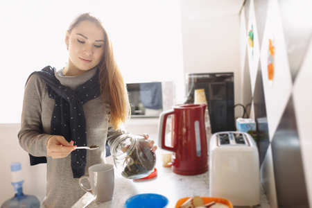 Attractive woman brew tea at her kitchenの写真素材