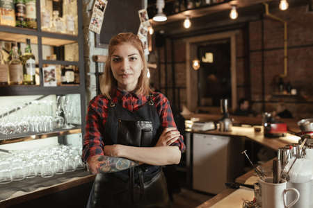 Portrait of young attractive woman bartender on barの写真素材