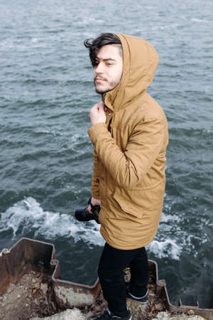 Photographer with camera standing near seaの写真素材