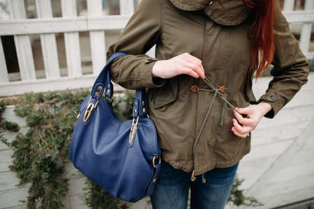 Woman laces coat against a wall background - cropped photoの写真素材
