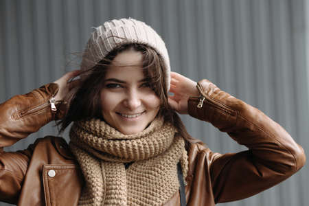 Portrait of young smiling girl in a hat at wall backgroundの写真素材