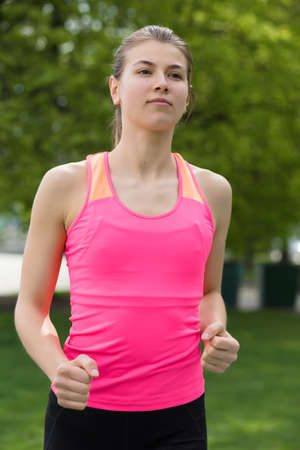 Young sporty woman running in park