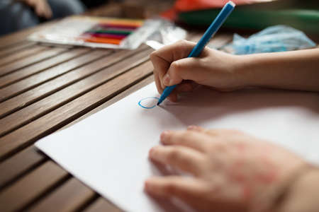 Child's hand drawing picture on a paperの写真素材