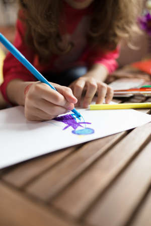 Child's hand drawing picture on a paperの写真素材