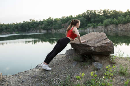 Woman push ups from a big boulderの写真素材
