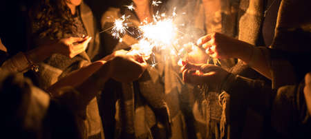 Women holding many sparklers in hands at nightの写真素材