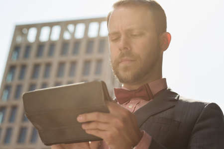 Businessman using digital tablet at high building backgroundの写真素材