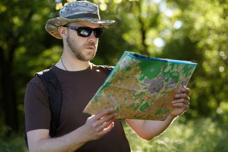 Male explorer looking at a map outdoorsの写真素材