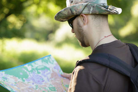 Male explorer looking at a map outdoors
