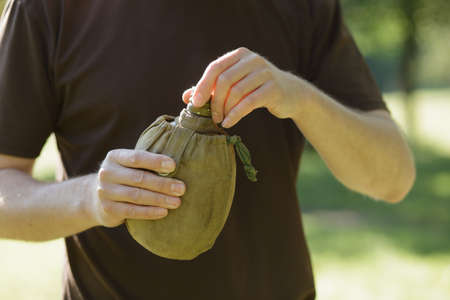 Man holding a flask of water in hike. Cropped shot.の写真素材