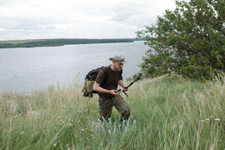 Hiker walking in the field and filming on action cameraの写真素材