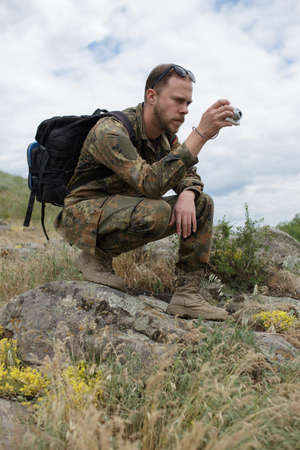 Male tourist shooting nature with compact camera outdoor