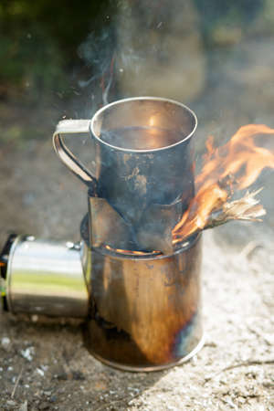 Camping fire cooker and steel tea mugの写真素材