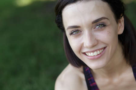 Close up portrait of young sporty woman at grass backgroundの写真素材