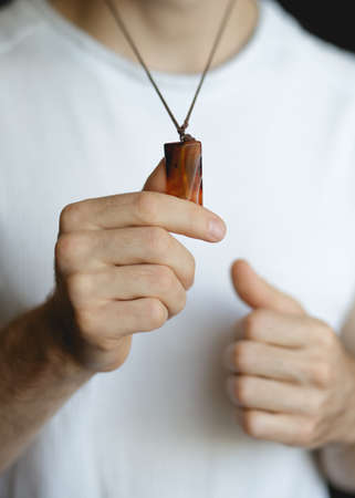 Man holding sardonyx pendant closeupの写真素材