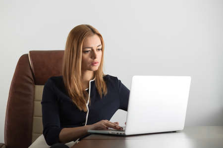 Attractive adult woman sitting at her workstation in the office