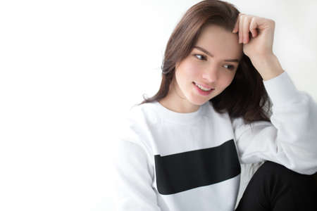 Cute woman in pullover sitting on white backgroundの写真素材