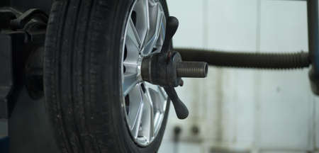 Tire service. Mechanic balancing a car wheel on automated machine.の写真素材