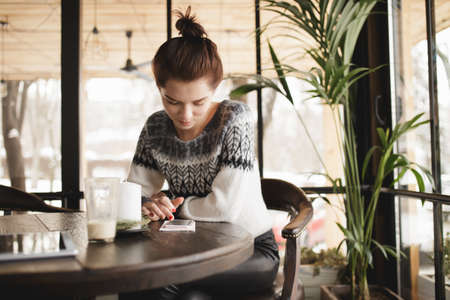 Modern woman using tablet pc and smartphone in a cafeの写真素材