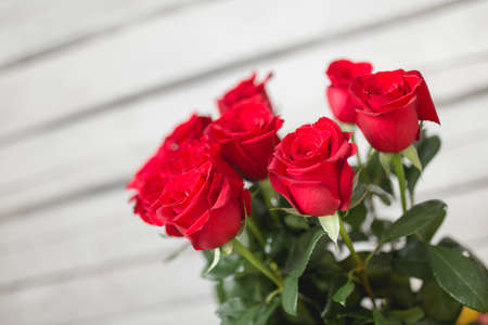Bouquet of red roses on white wooden backgroundの写真素材