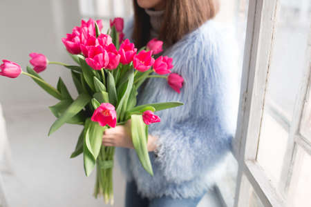 Cropped shot of unrecognizable girl holding bouquet of pink tulipsの写真素材