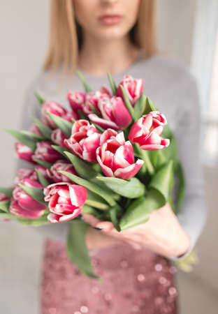 Cropped shot of unrecognizable woman holding bouquet of tulipsの写真素材