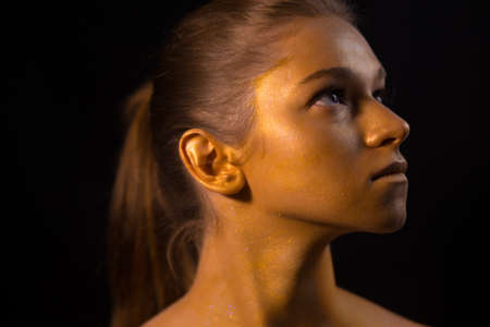 Professional model posing with bronze art makeup on her faceの写真素材