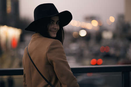 Funky woman in hat smiling and having fun, city background