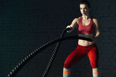 Woman make exercise with battle rope in functional training gymの写真素材