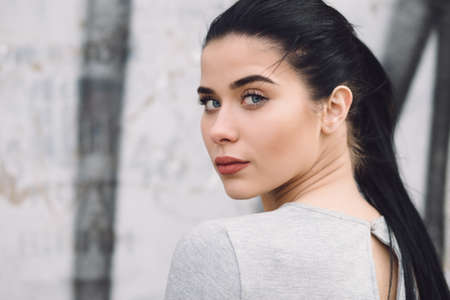Closeup portrait of woman at street wall, she looking at cameraの写真素材