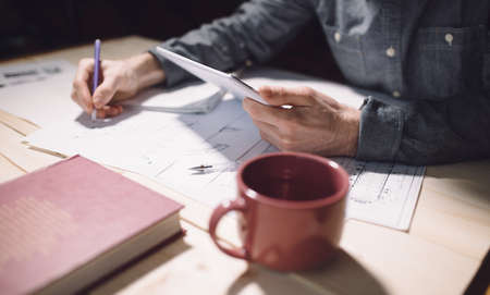 Hands of male engineer drawing on a table