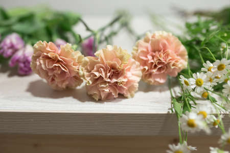 Different flowers on a wooden table