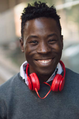 Closeup portrait of smiling african american man with headphones in city streetの写真素材