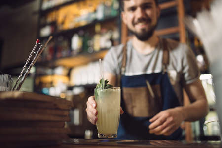 Young male bartender preparing an alcohol cocktail at a bar counterの写真素材