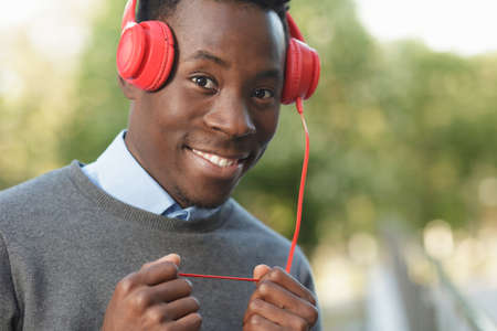 African american man listening to music with his headphones in park at summer day
