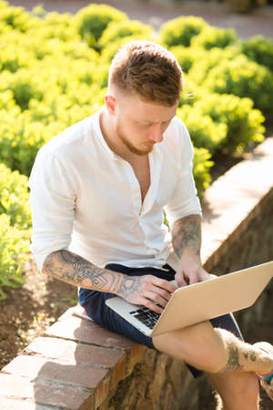 Man freelancer working with laptop in a nature