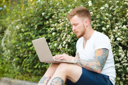 Man enjoying to freelance works anywhere. He using laptop in a park.の写真素材