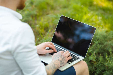 Man enjoying to freelance works anywhere. He using laptop in a park.の写真素材