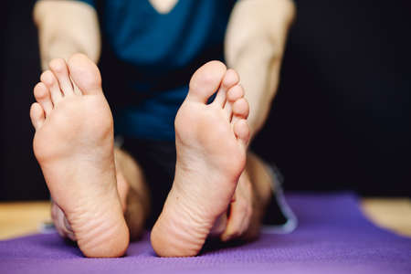 Cropped shot of male stretching legs on floor matの写真素材