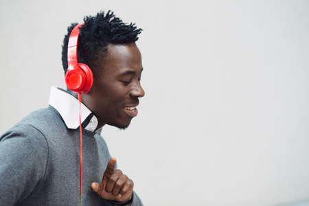 Closeup portrait of african american man enjoy to listening music with headphones and dancingの写真素材