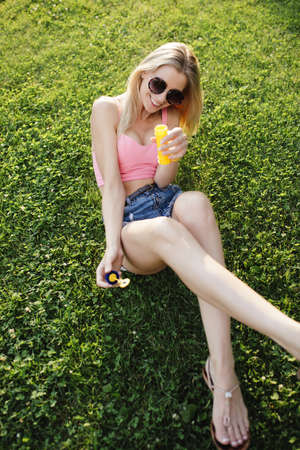 Pretty happy woman blowing bubbles in park, she enjoy summer holidayの写真素材