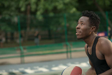 African american man plays on street basketball court. Real and authentic activity.の写真素材