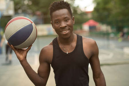 Portrait of smiling african american man on basketball court keep ballの写真素材