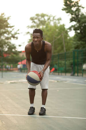 African american man on basketball court dribbling with ball. Real and authentic activity.の写真素材