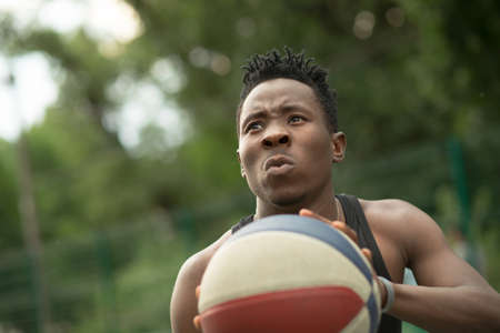 Portrait of african american man throw ball on basketball courtの写真素材