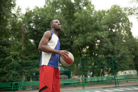 African american man plays on basketball court. Real and authentic activity.の写真素材